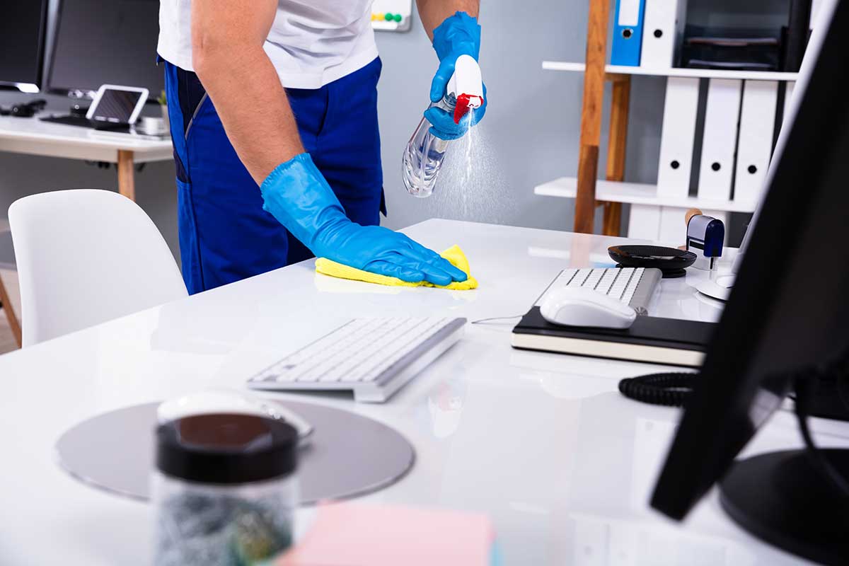 Female janitor with vacuum cleaner in room
