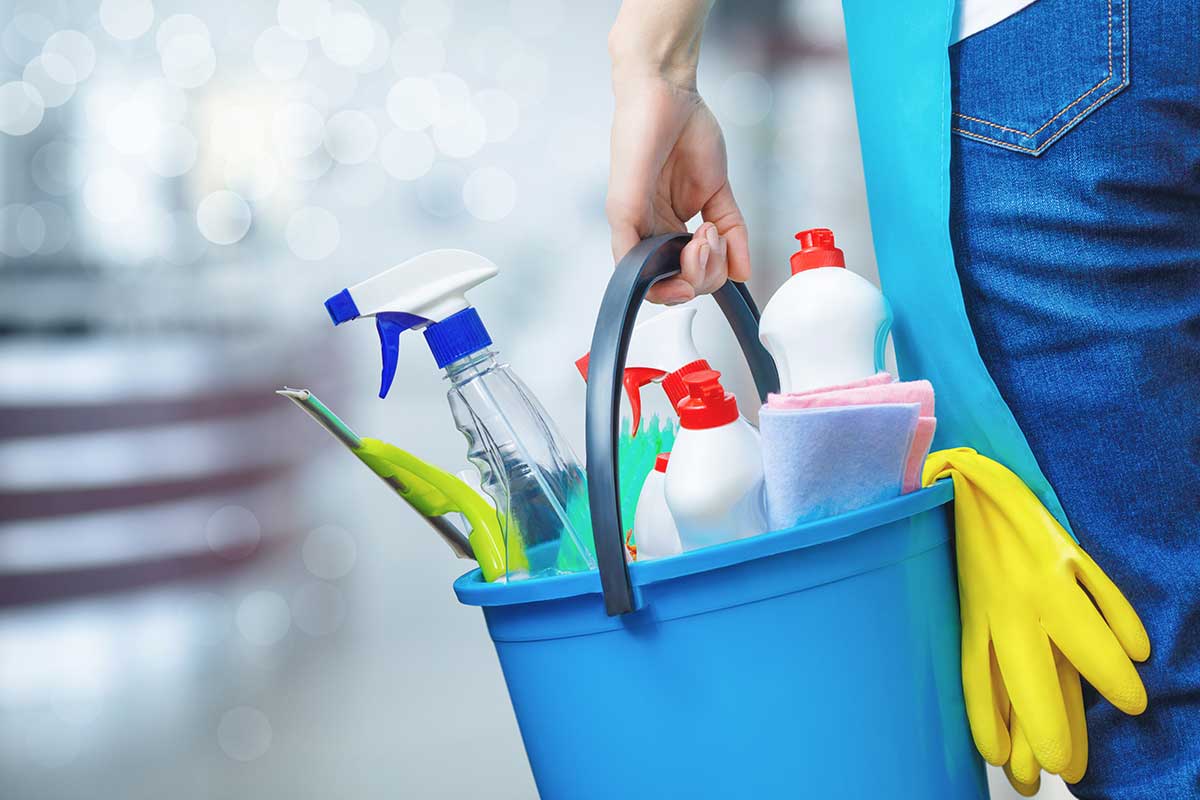 holding cleaning products and tools on bucket, close up